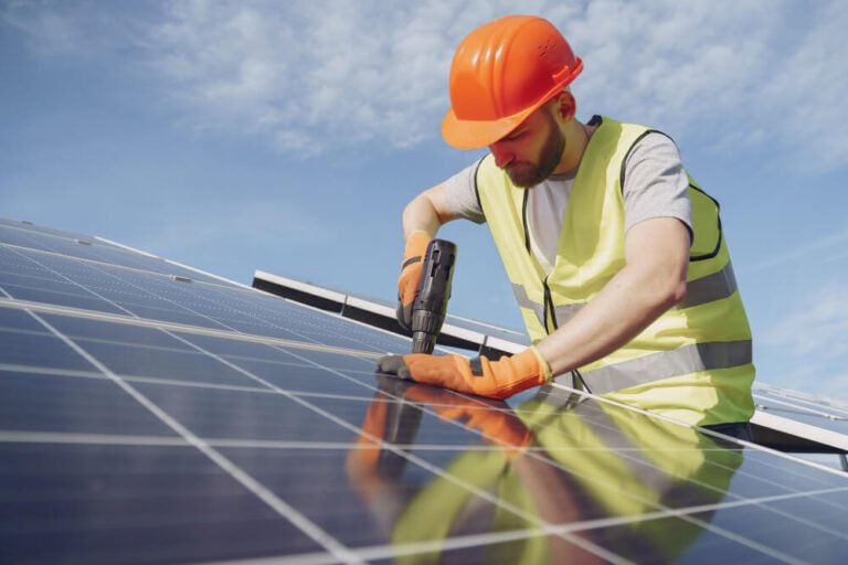 Electrician installing solar panel electrical wiring and inverter on a residential rooftop