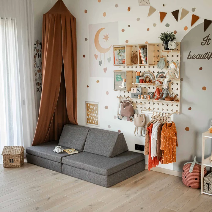 Wall-mounted picture ledges and pegboard storage in a children's bedroom